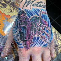 a tattoo of a man with a spider on his hand